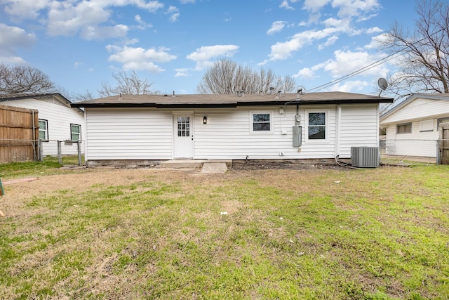 back of property featuring a yard, central air condition unit, and fence