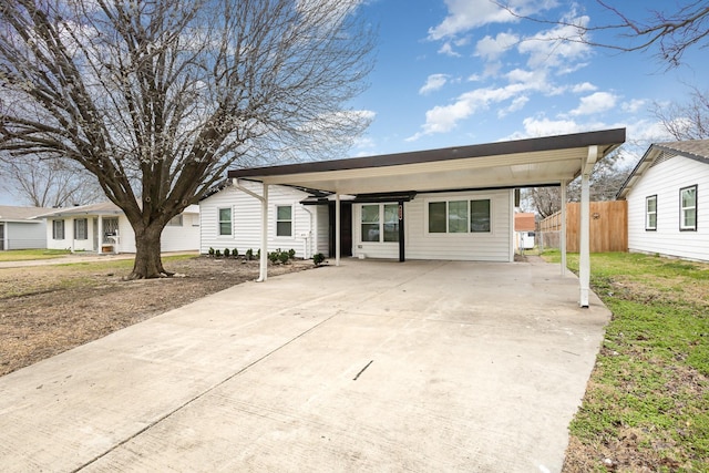 view of front of property featuring a carport, driveway, and fence