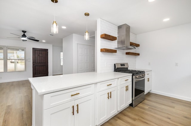 kitchen featuring light wood finished floors, open shelves, decorative backsplash, gas range, and wall chimney range hood