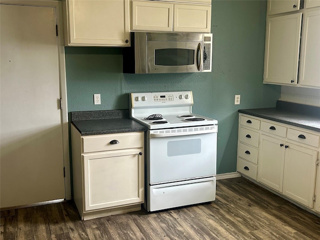 kitchen with dark wood-type flooring, white electric range, stainless steel microwave, dark countertops, and decorative backsplash