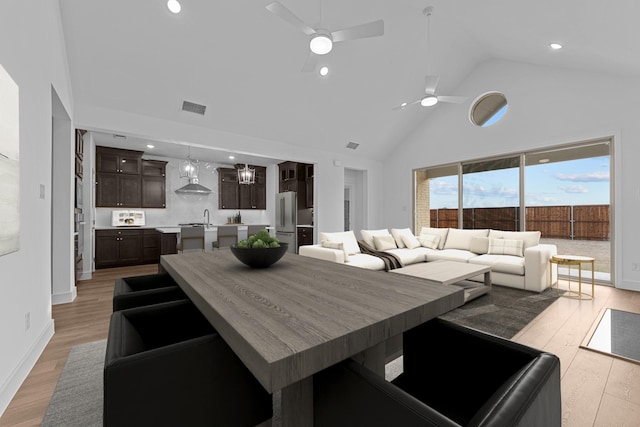 dining room featuring a ceiling fan, visible vents, light wood finished floors, high vaulted ceiling, and recessed lighting