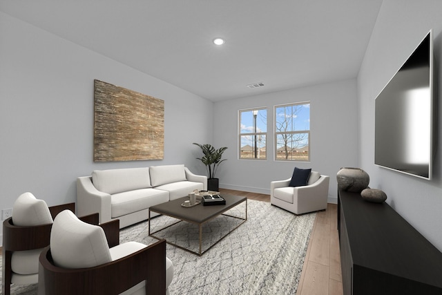 living room with recessed lighting, light wood-style floors, and baseboards