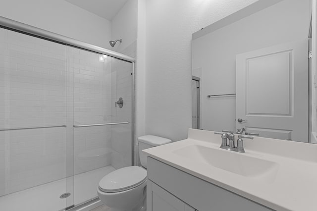 full bath featuring vanity, toilet, and a shower stall