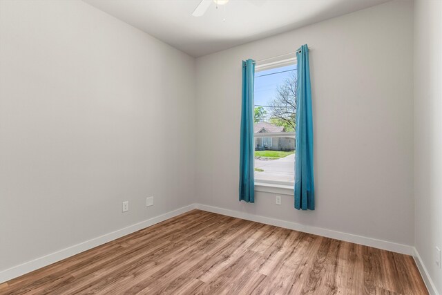 unfurnished room featuring baseboards, light wood-type flooring, and a ceiling fan