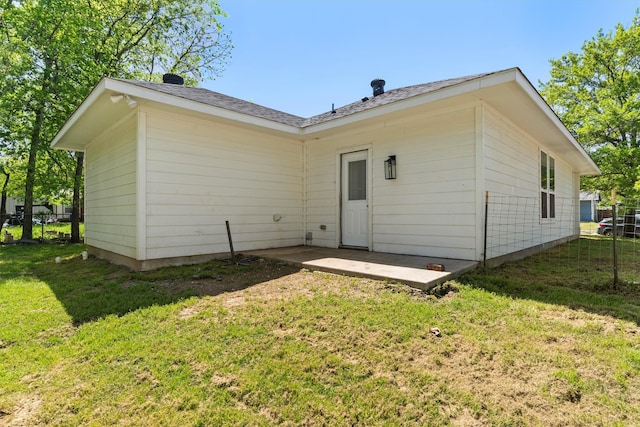 back of house with a yard and a patio