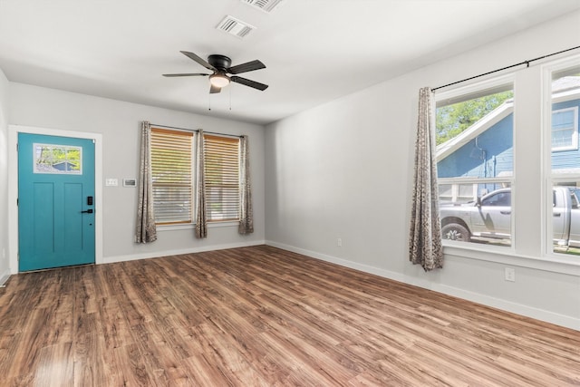 interior space featuring visible vents, baseboards, a ceiling fan, and wood finished floors