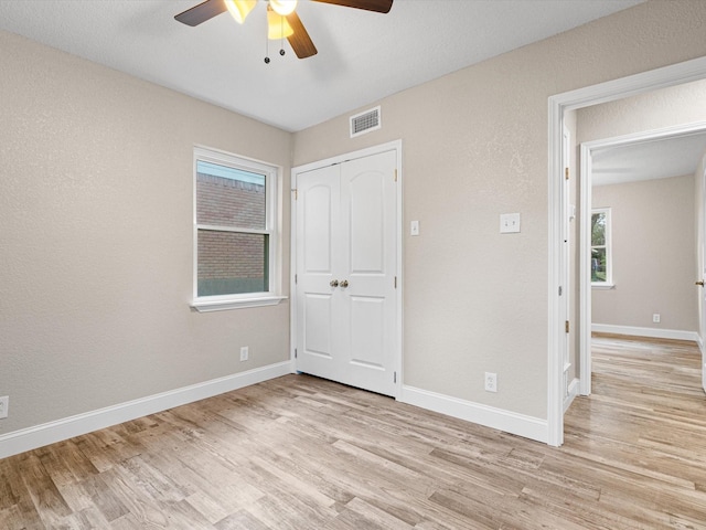 unfurnished bedroom with baseboards, visible vents, a closet, and light wood-type flooring