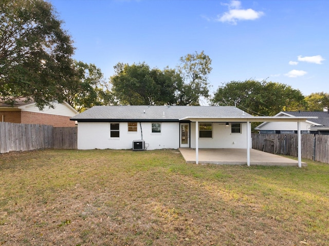 rear view of property featuring a patio area, a yard, and a fenced backyard