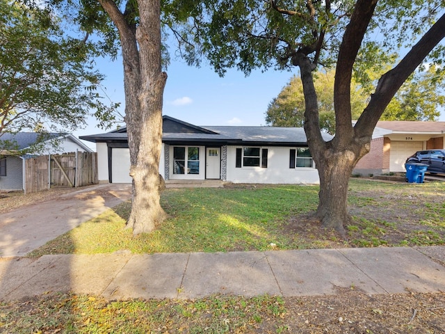 ranch-style home with a front yard, fence, and driveway