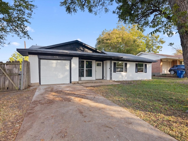 single story home featuring a front yard, fence, driveway, an attached garage, and brick siding