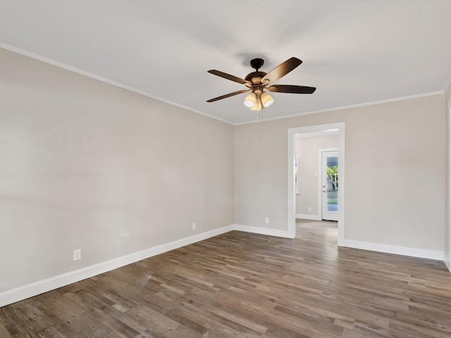 spare room with baseboards, wood finished floors, a ceiling fan, and ornamental molding