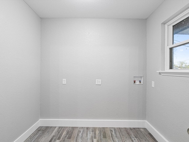 clothes washing area featuring laundry area, hookup for a washing machine, wood finished floors, and baseboards