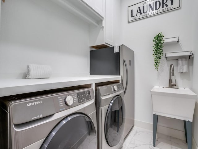 clothes washing area featuring cabinet space, separate washer and dryer, marble finish floor, and baseboards