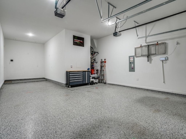 garage with a workshop area, a garage door opener, and baseboards