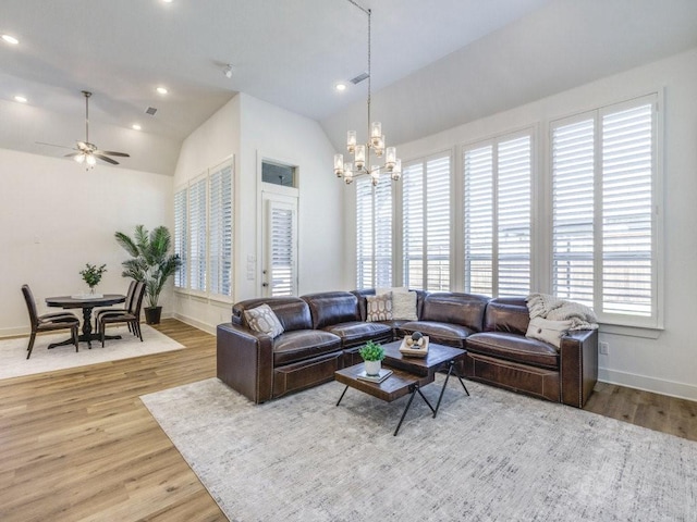 living room with recessed lighting, lofted ceiling, wood finished floors, and ceiling fan with notable chandelier