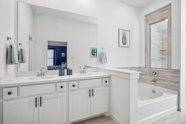 bathroom featuring double vanity, connected bathroom, a bath, and a sink