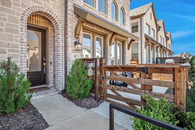 property entrance with brick siding and a gate