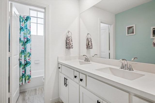 bathroom with a sink, shower / tub combo with curtain, and double vanity