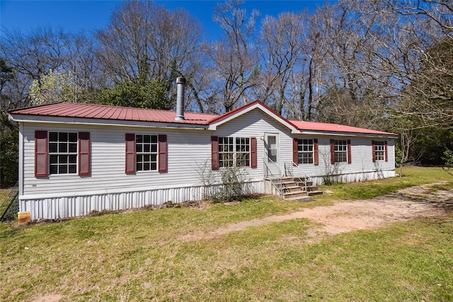 manufactured / mobile home with a front lawn and metal roof