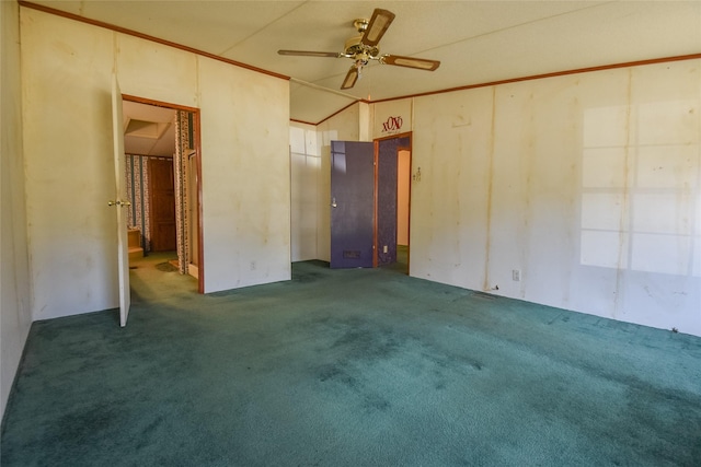 carpeted empty room featuring ceiling fan, crown molding, and vaulted ceiling