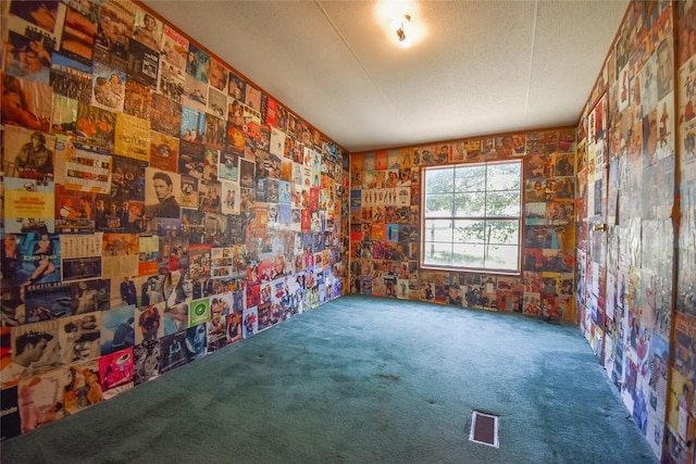 unfurnished room with carpet flooring, visible vents, and a textured ceiling