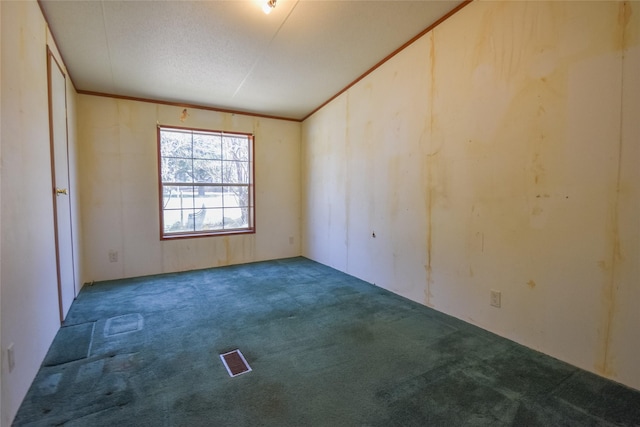 unfurnished room with a textured ceiling, carpet flooring, and ornamental molding