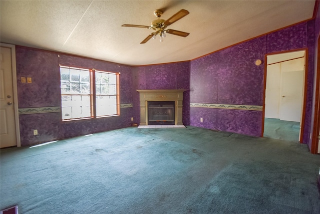 unfurnished living room with a glass covered fireplace, a textured ceiling, wallpapered walls, and carpet