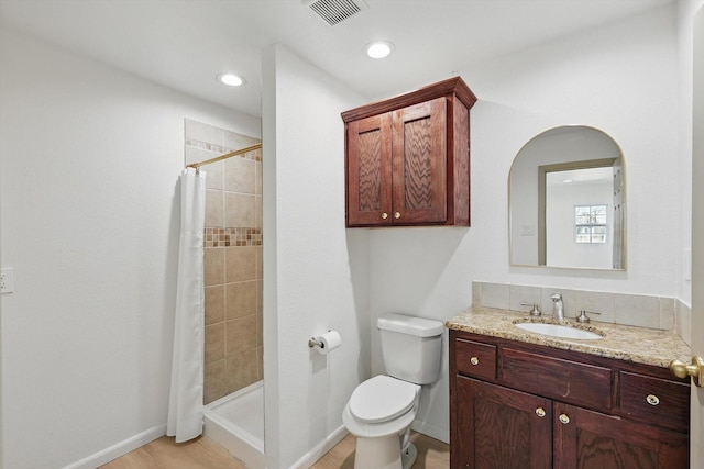 full bathroom with vanity, baseboards, visible vents, a tile shower, and toilet