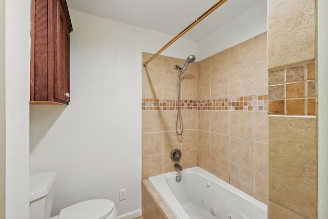 bathroom with toilet and a combined bath / shower with jetted tub