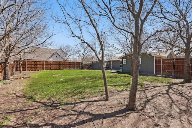 view of yard with a fenced backyard and a gate