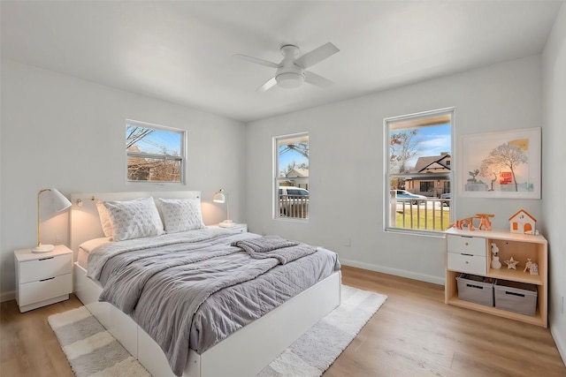 bedroom with a ceiling fan, light wood-type flooring, and baseboards