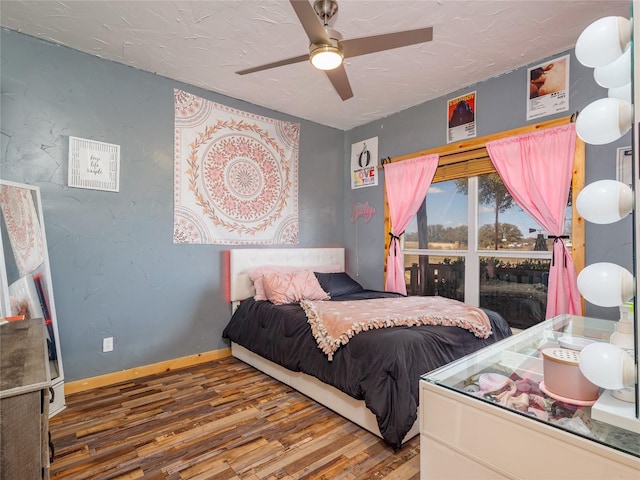 bedroom with ceiling fan, baseboards, a textured ceiling, and wood finished floors