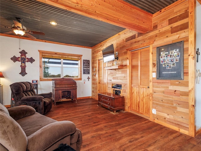 living area with wooden walls, a ceiling fan, and dark wood-style flooring