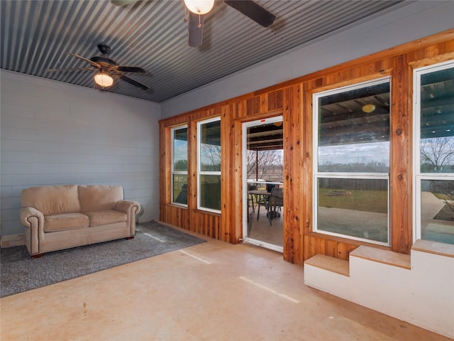 unfurnished sunroom featuring a ceiling fan