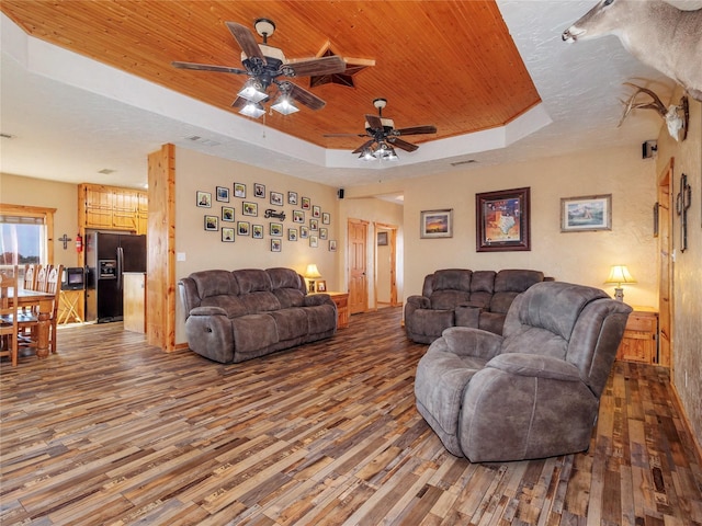 living room featuring wood ceiling, a raised ceiling, and wood finished floors