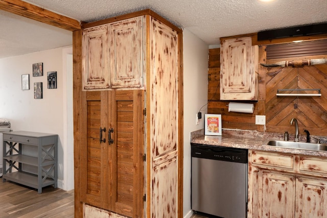 1719 E Bankhead Dr, Weatherford, TX 76086 - kitchen featuring stainless steel dishwasher, a sink, a textured ceiling, and light wood-type flooring