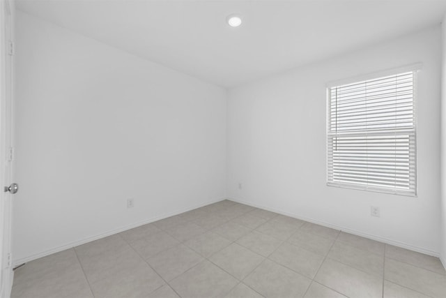 spare room with recessed lighting and baseboards