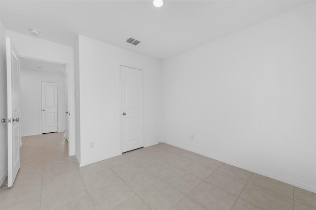 spare room with light tile patterned floors, baseboards, and visible vents