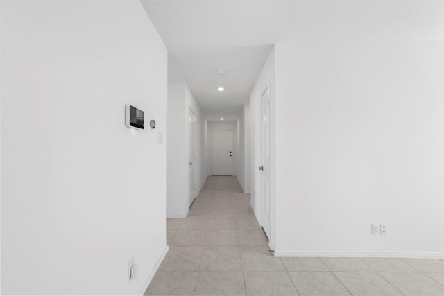 hallway featuring light tile patterned floors, recessed lighting, and baseboards