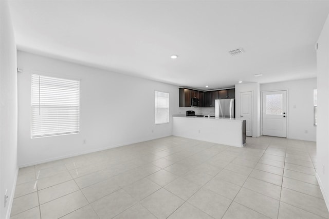 unfurnished living room with light tile patterned floors, visible vents, baseboards, and recessed lighting