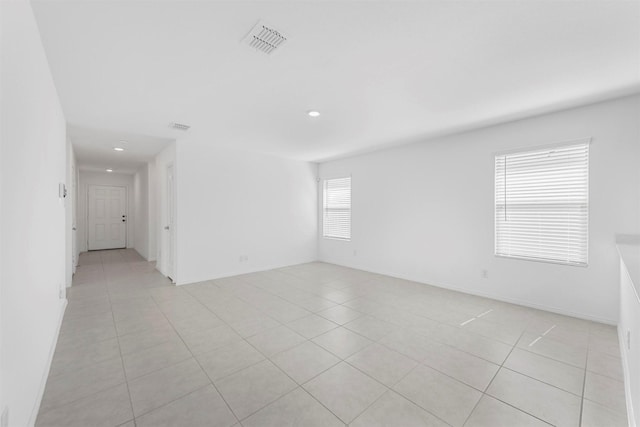 spare room featuring visible vents, baseboards, and light tile patterned flooring