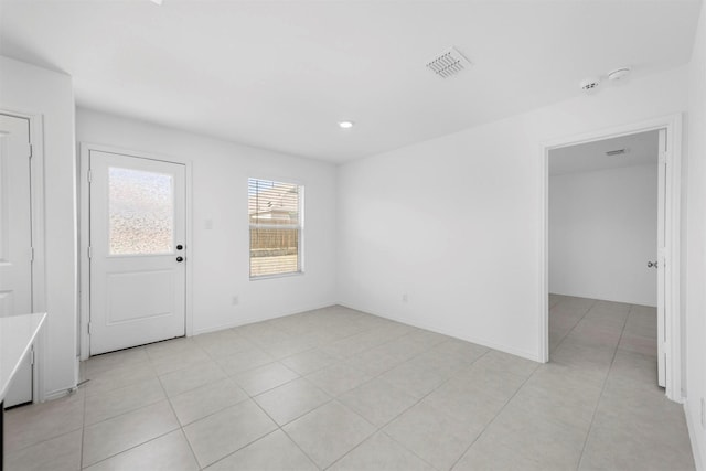 spare room featuring light tile patterned flooring, baseboards, and visible vents