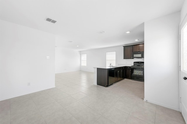 kitchen with visible vents, a peninsula, black appliances, dark brown cabinets, and open floor plan