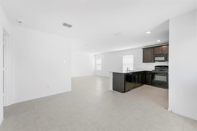 kitchen with visible vents, black appliances, open floor plan, dark brown cabinetry, and a peninsula