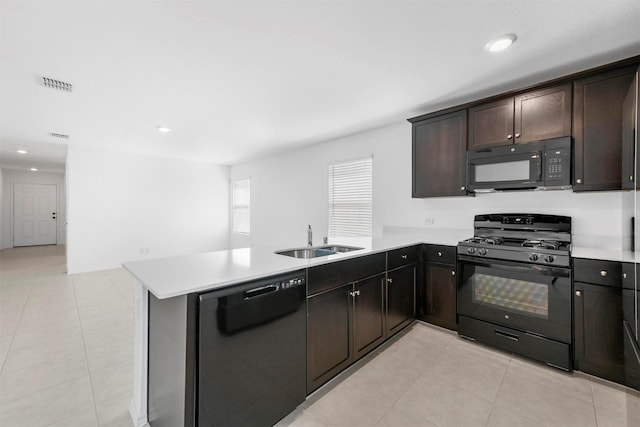 kitchen featuring visible vents, light countertops, a peninsula, black appliances, and a sink