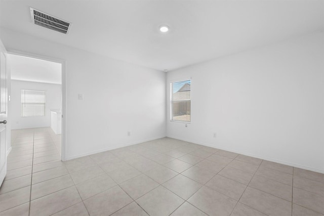 unfurnished room with light tile patterned floors, baseboards, and visible vents