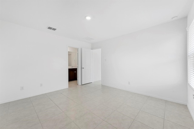 unfurnished room featuring light tile patterned floors, visible vents, a healthy amount of sunlight, and baseboards