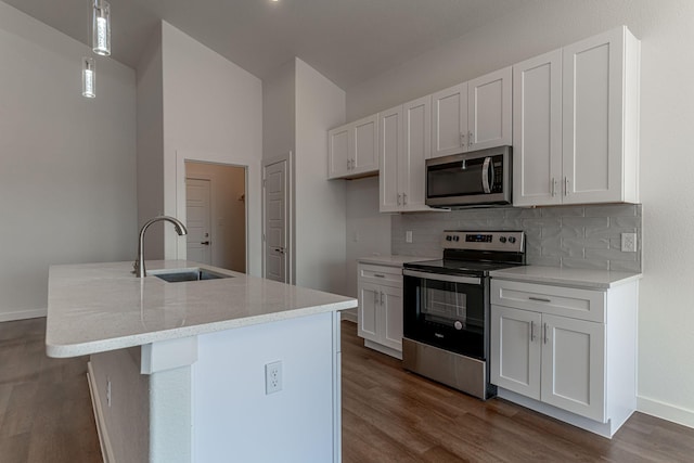 kitchen with dark wood finished floors, backsplash, appliances with stainless steel finishes, and a sink