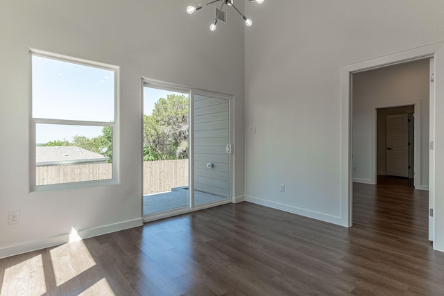 empty room with baseboards and dark wood finished floors