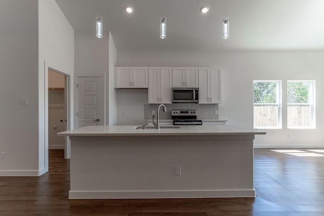 kitchen featuring a sink, decorative backsplash, light countertops, dark wood-type flooring, and appliances with stainless steel finishes